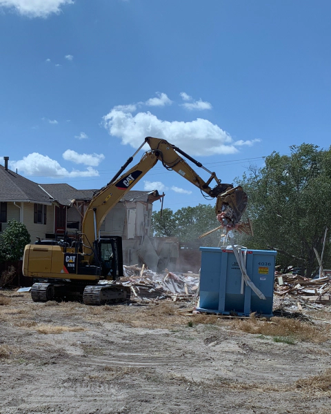 excavator putting debris into dumpster wichita ks